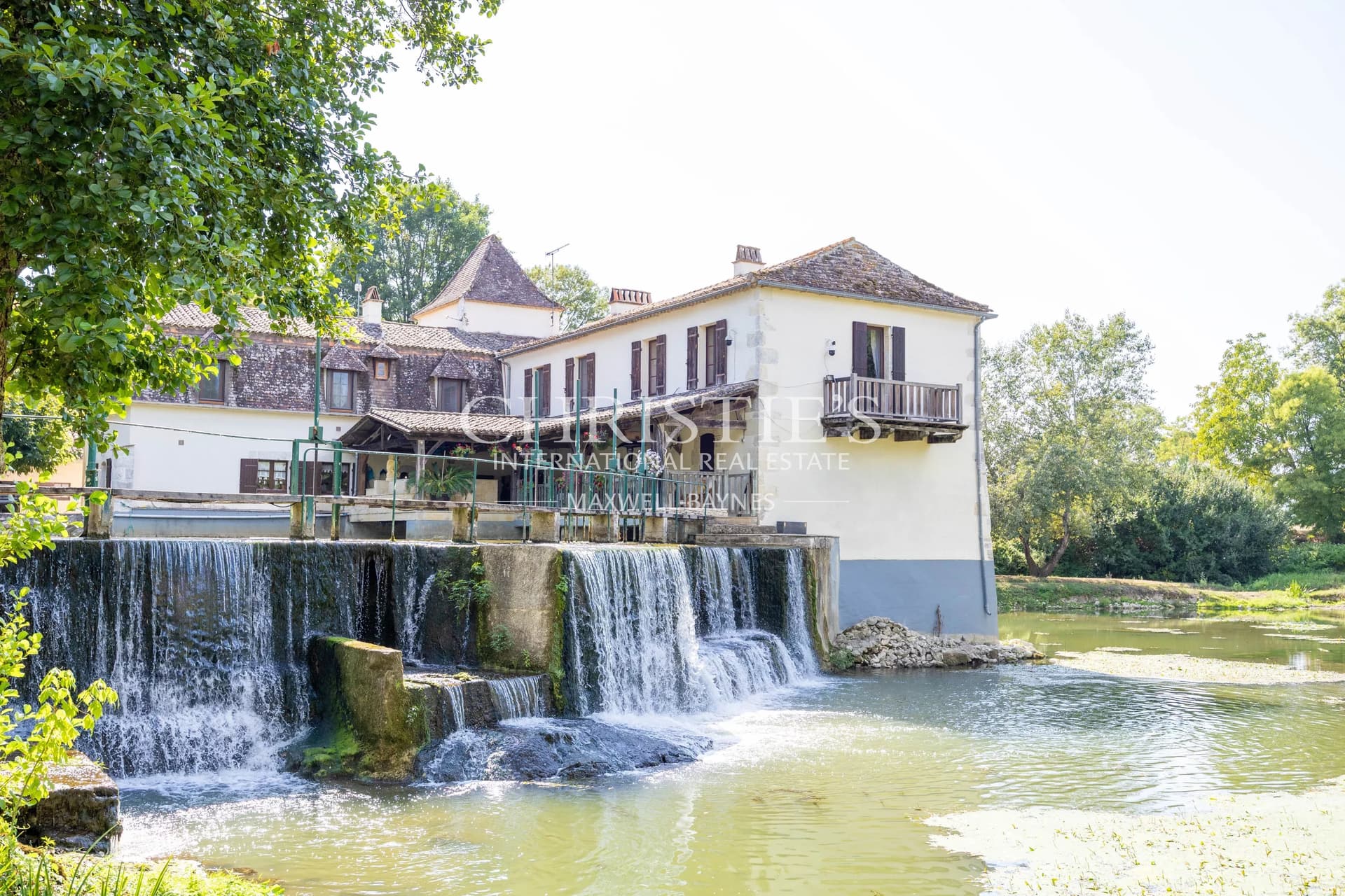 La maison du moulin, située au bord de la rivière Dropt, surplombe son lac et s’étend au cœur d’un domaine boisé de 13 hectares